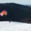 Paraglider launching off the snowy Poo Poo Point with Lake Sammamish in the background
