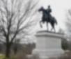 Statue of a general riding a horse atop a white pedestal