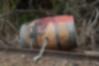 A barrel with spray paint is chained to railroad tracks