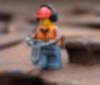 A construction worker jack hammers a railroad nail
